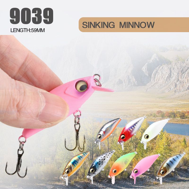 A pink sinking minnow lure held between two fingers