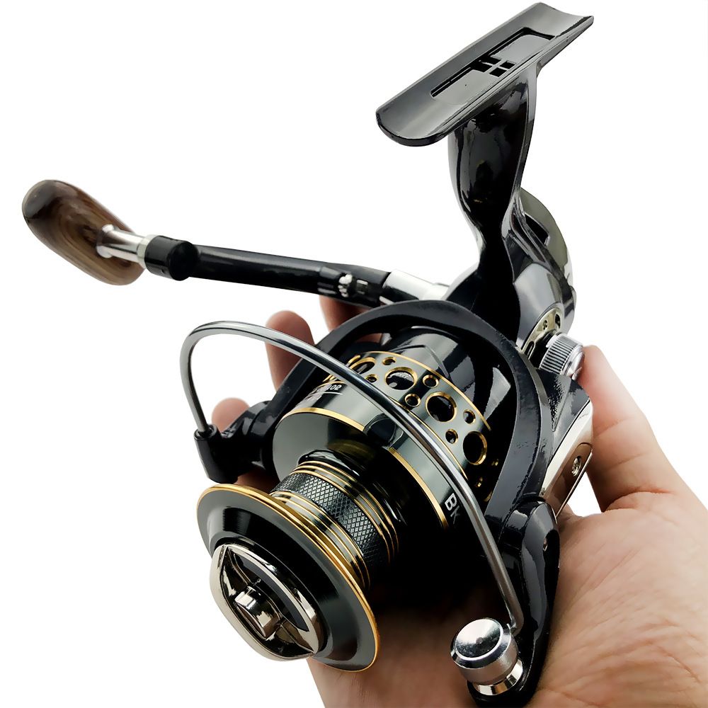 A black and gold spinning reel held in a hand